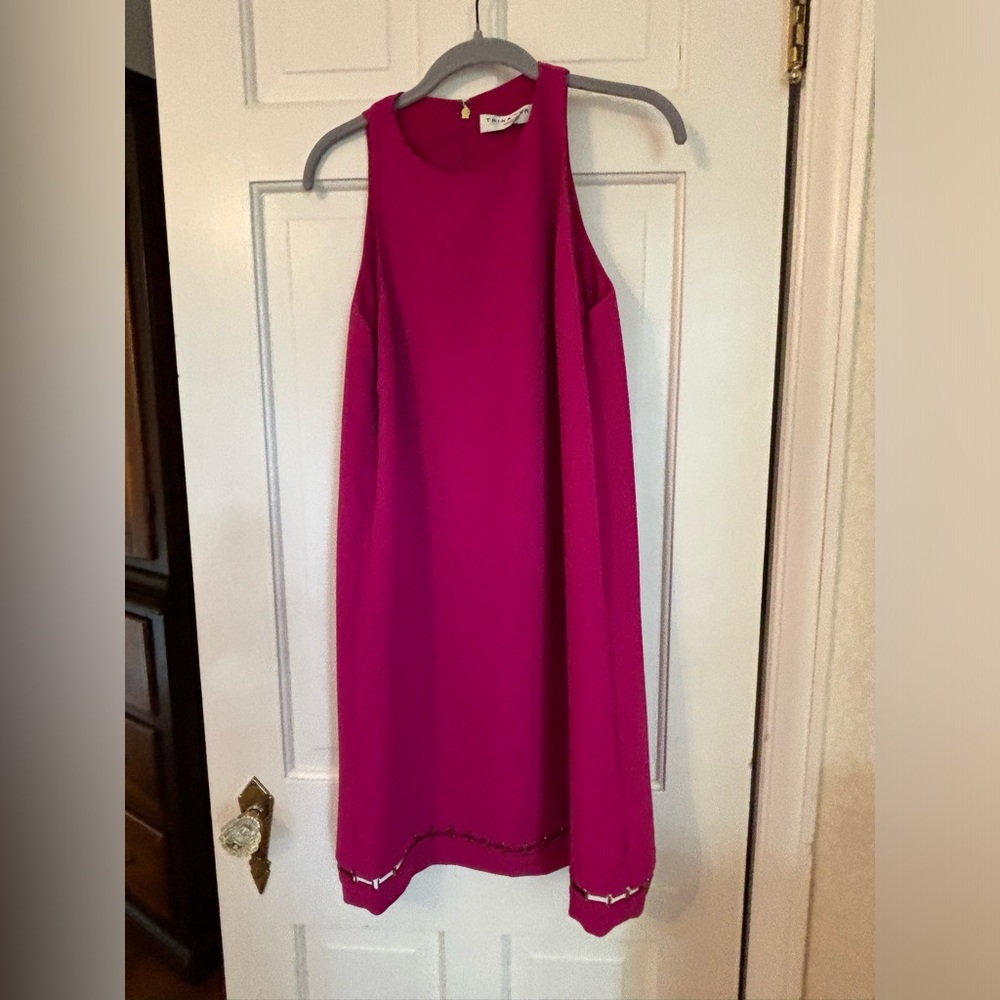Trina Turk size 12.A/line, knee length, with brass detail at the bottom.